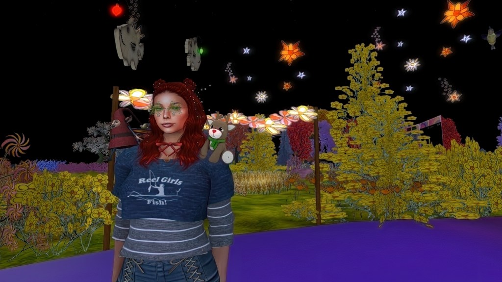 CK Ballyhoo in her Flower Power build at Hippiestock 2026 in Second Life, surrounded by hand-painted flowers and glowing lights